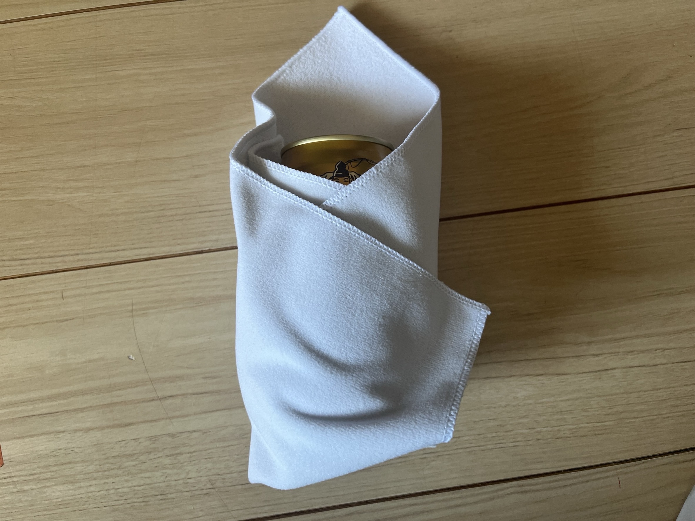 保冷保温タオルで缶ビールをくるんだ様子