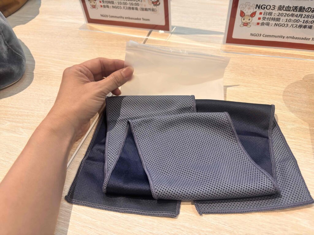 フロッタ／クールタオル（ジッパーケース入）を折り重ねて机に置いている