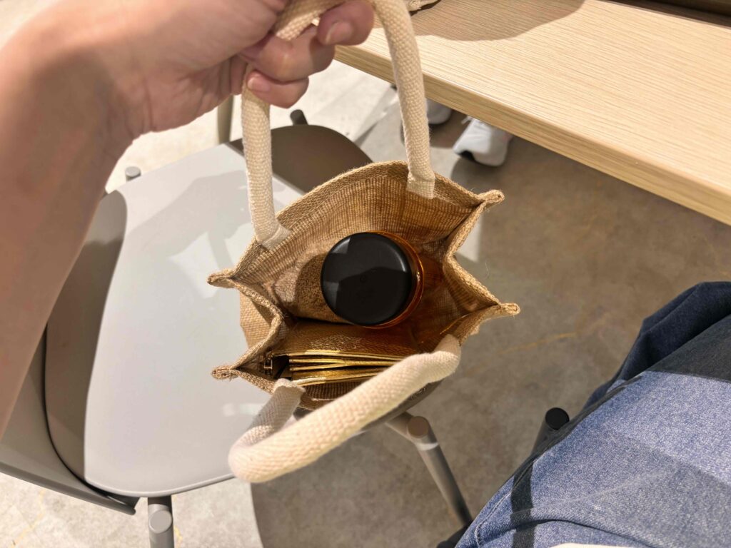 ジュートミニバッグにボトルと財布が入っている