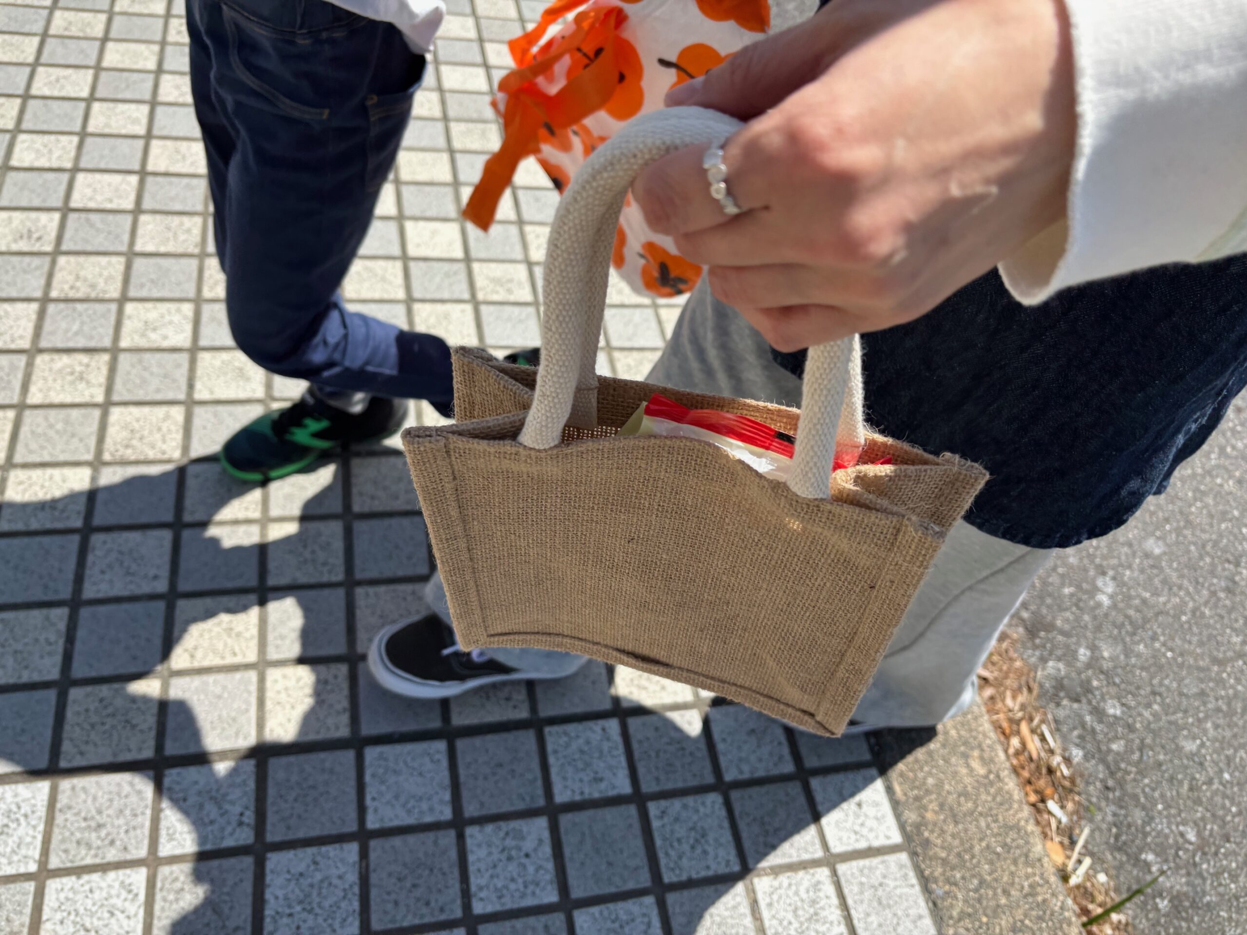 ジュートミニバッグにお菓子やハンカチを入れて持ち歩く様子