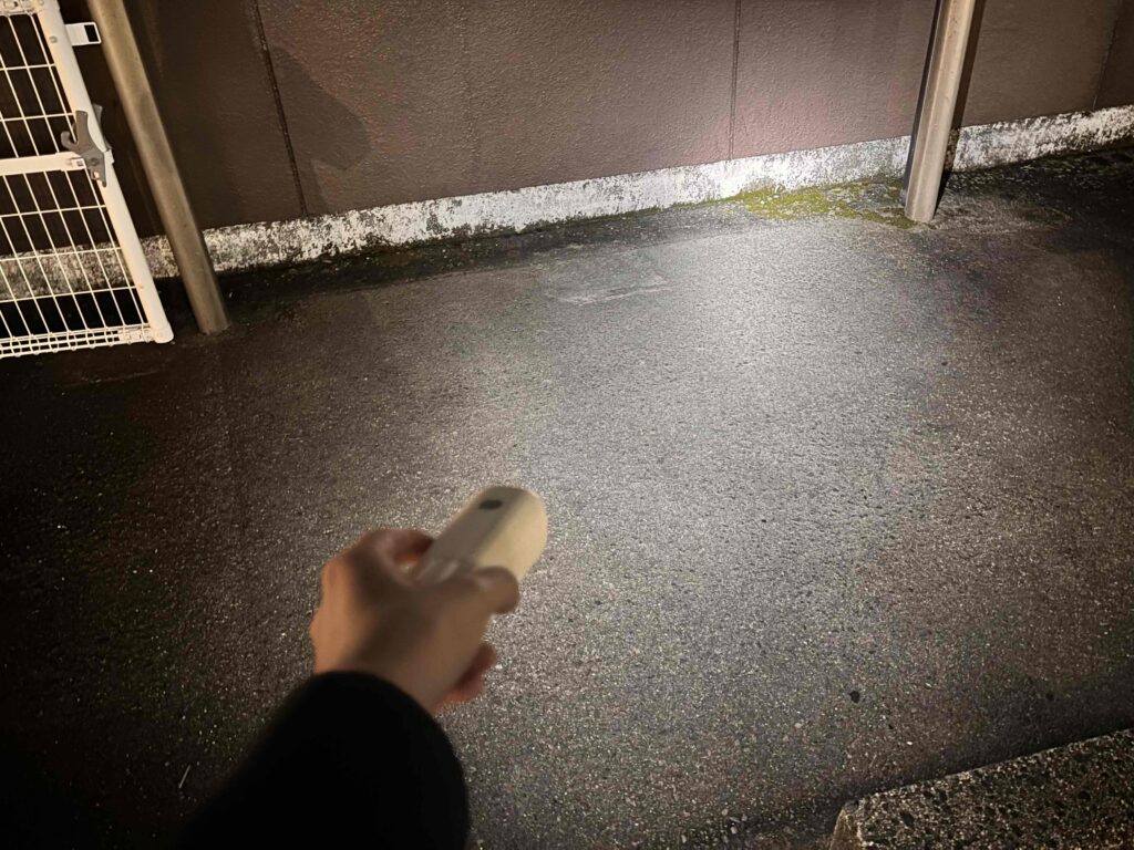 ハンディランタンのライトを壁にあてている