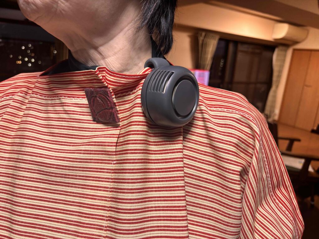 360度回転クリップファンを襟元に取り付けている女性
