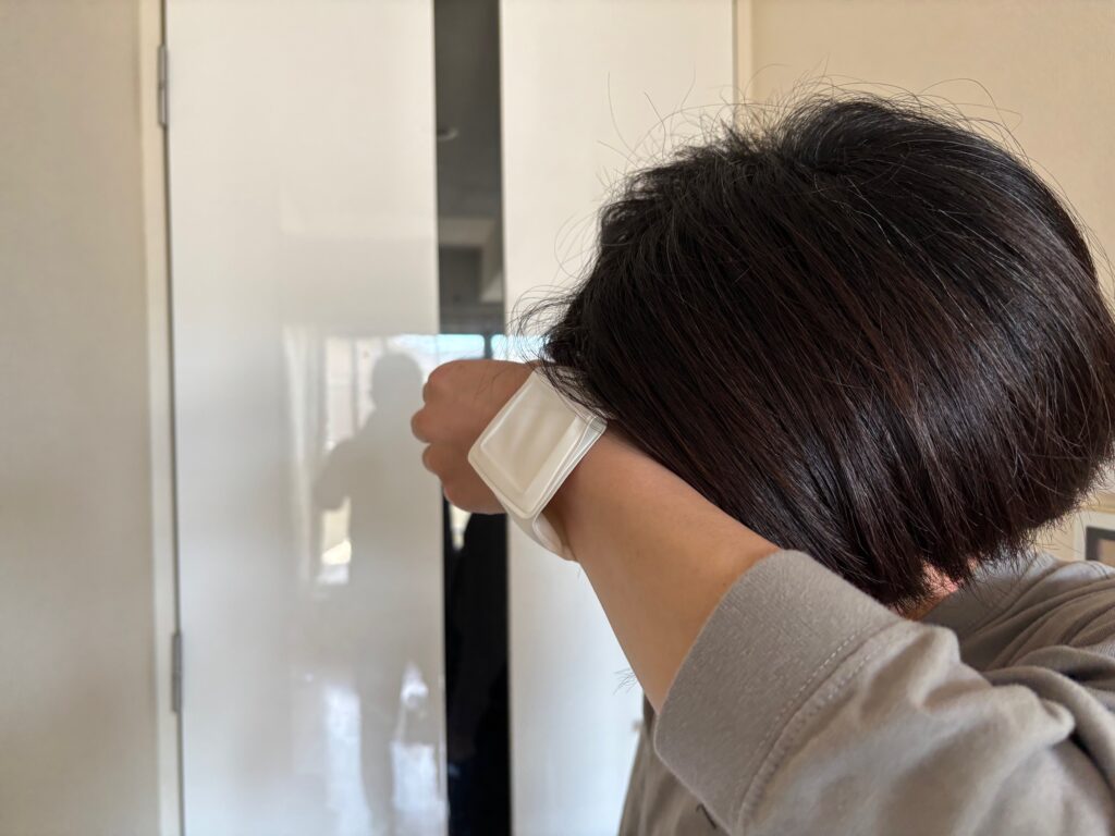 クールリストバンドを手首に巻き、額にあてている様子