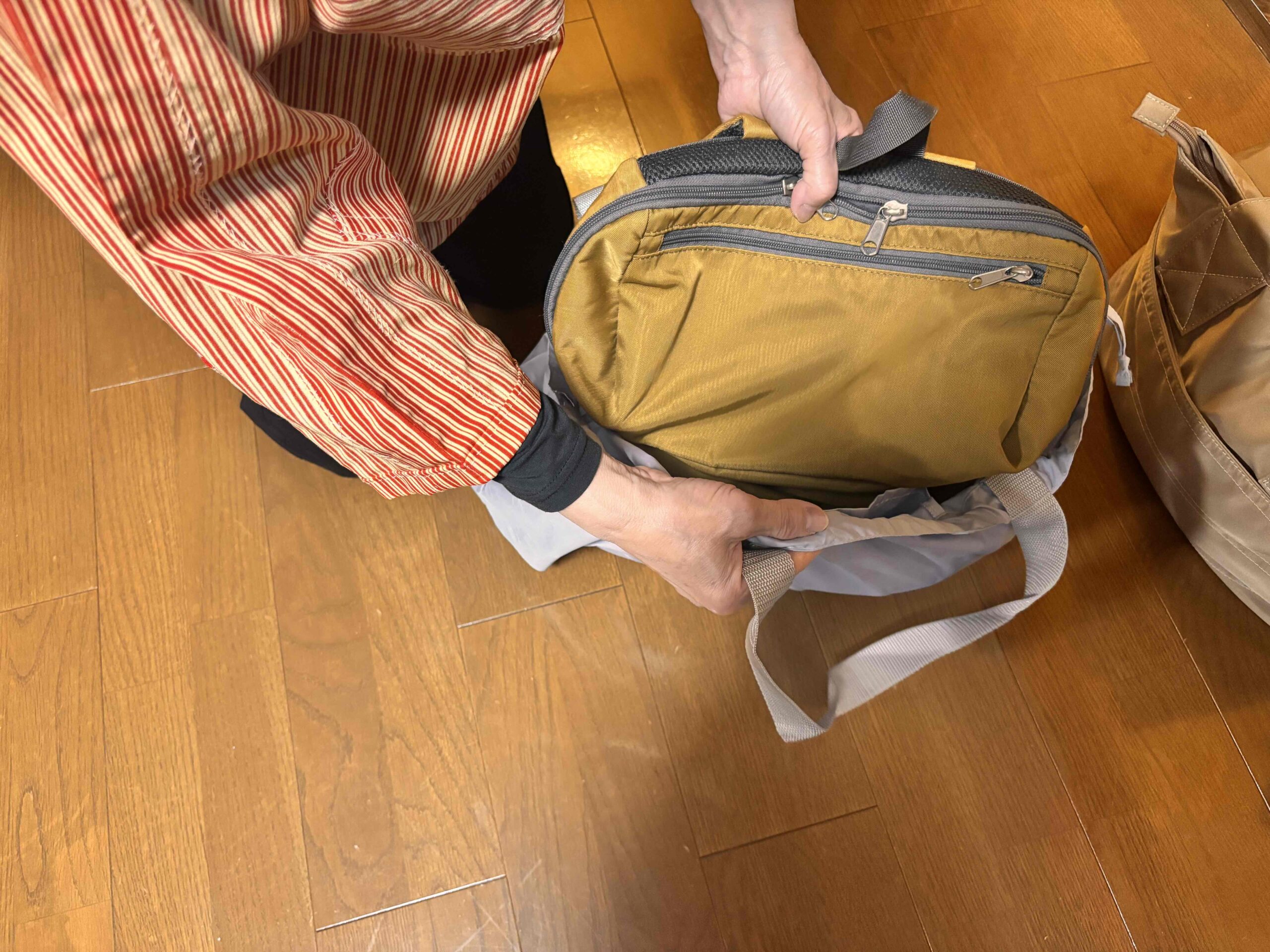レインカバーにもなる撥水バッグにカバンを入れる様子