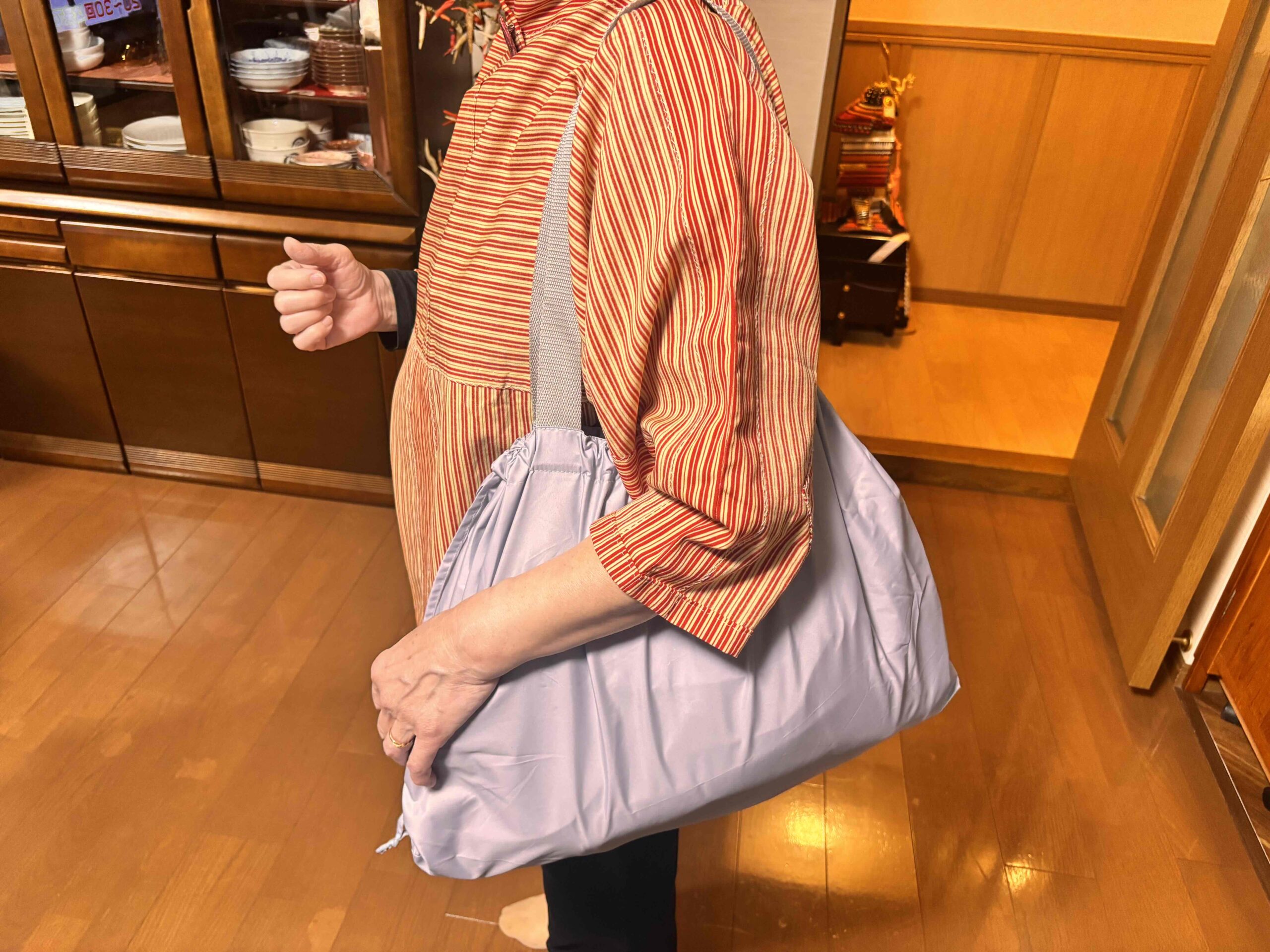 レインカバーにもなる撥水バッグにバッグを入れて方に掛けた女性