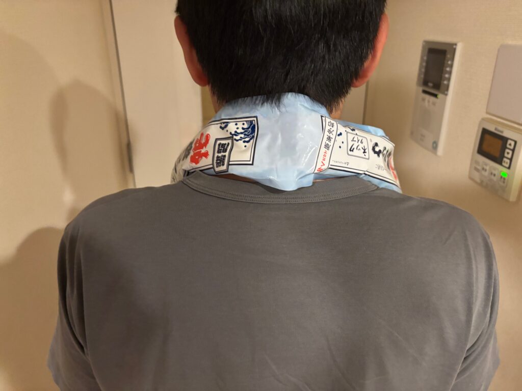 冷却パック ネックタイプを首に巻いた後ろ向きの男性