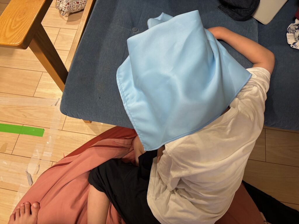 遮光UVカットタオルを頭にかぶせた子供