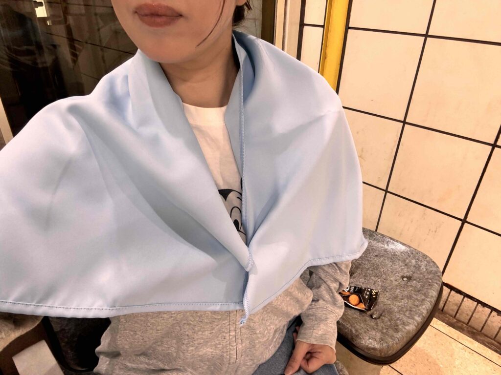 遮光UVカットタオルのボタンを留めて方に掛けた女性