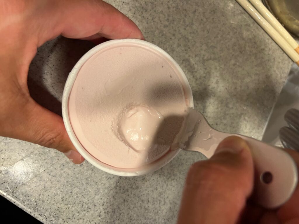 アイスクリームスプーンをカップアイスに入れる様子