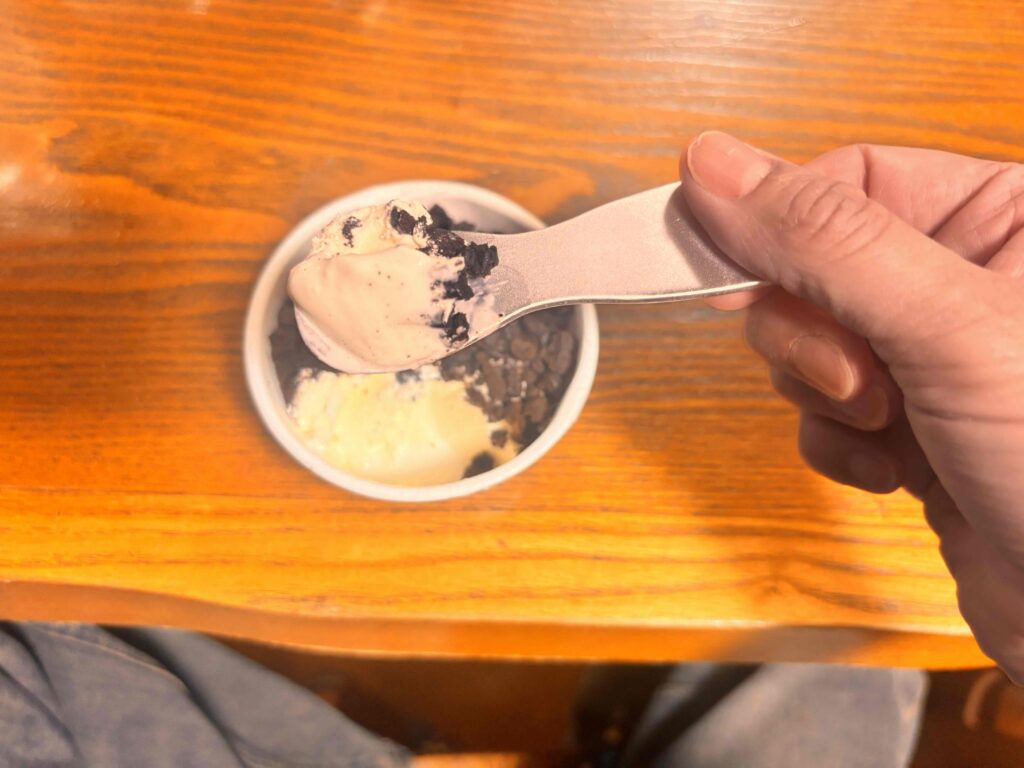 アイスクリームスプーンをカップアイスのアイスクリームを掬っている