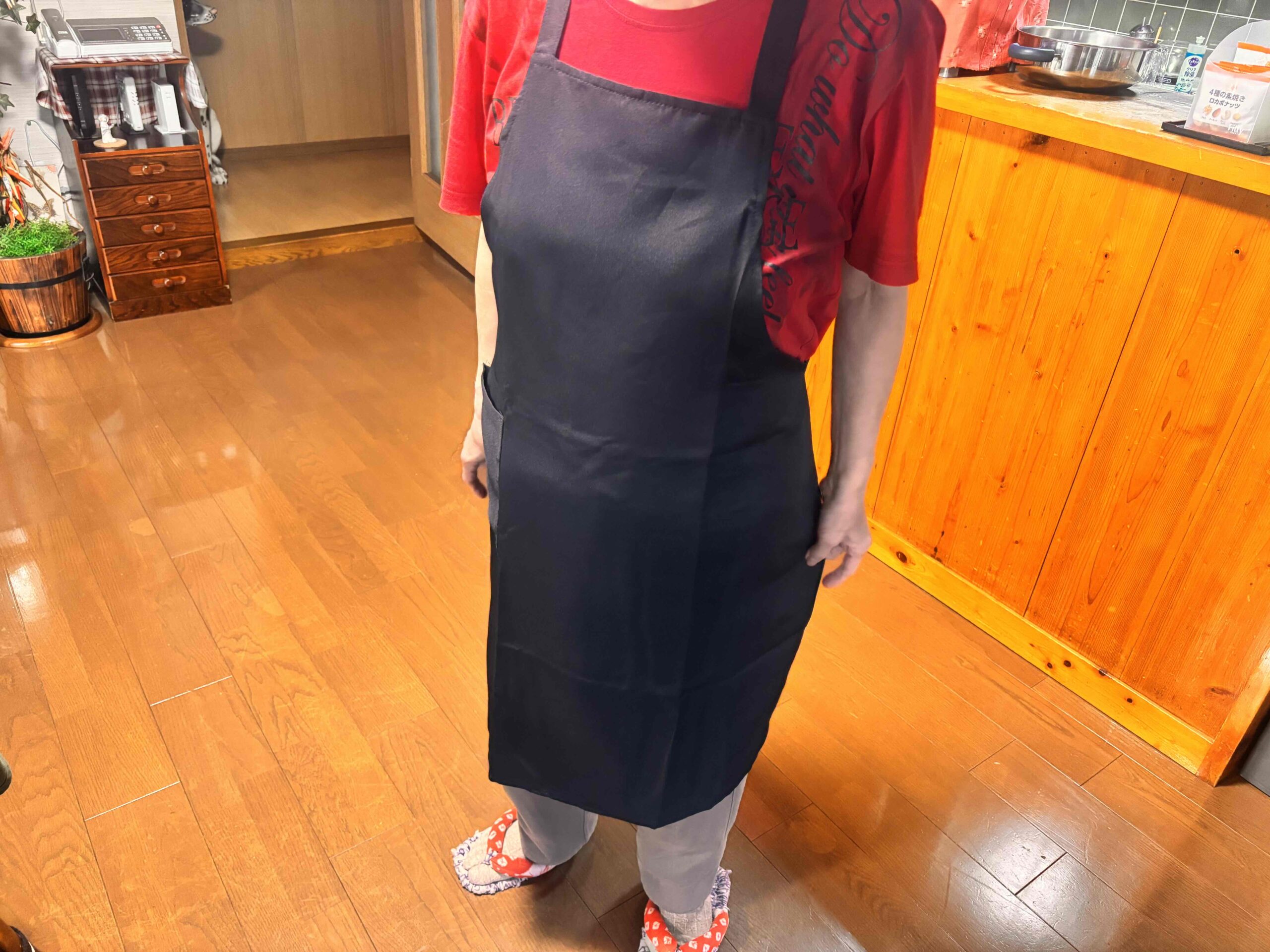 カスタムデザインエプロンを着用し立っている女性（左前方正面）