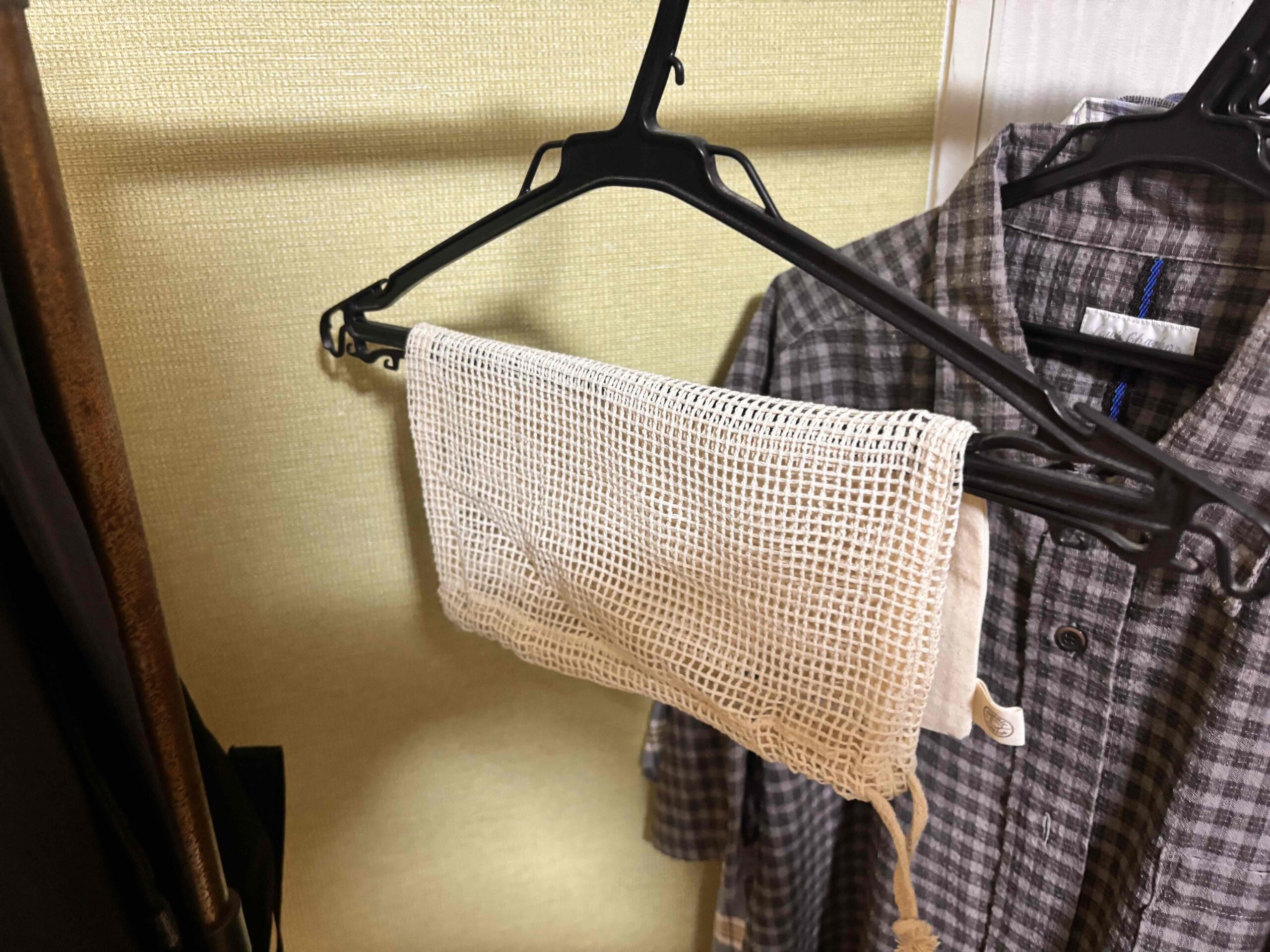 オーガニックコットンネット巾着（L）　ナチュラルをハンガーにかけてほしている