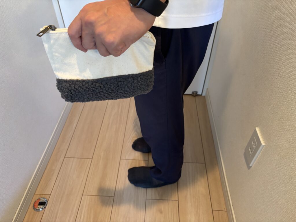 ボア＆キャンバスデイリーポーチを手に持ち立っている男性