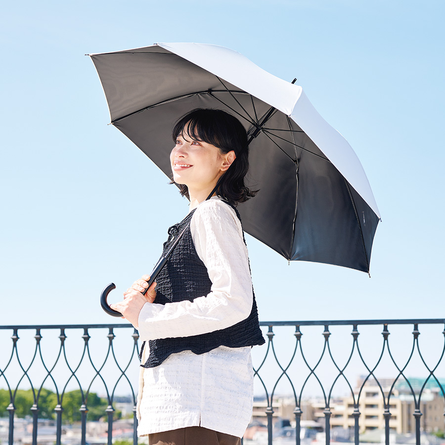 遮光長傘 日傘をさして青空を見上げている女性