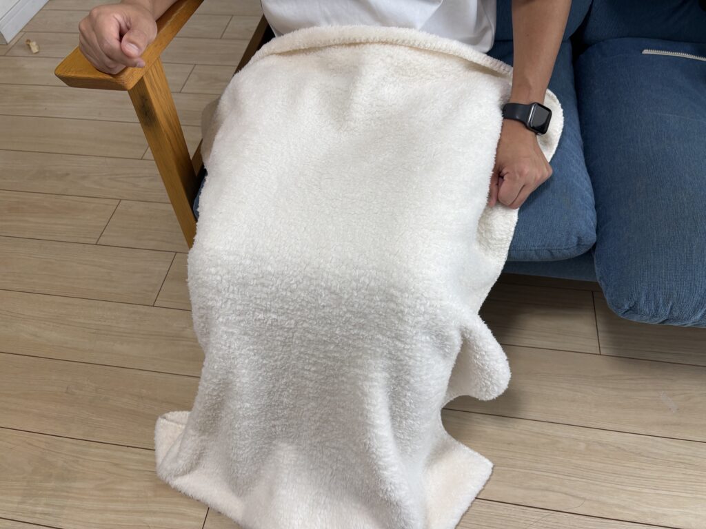 カチオン染めレギュラーブランケット（巾着付）アイボリーを膝にかけた男性