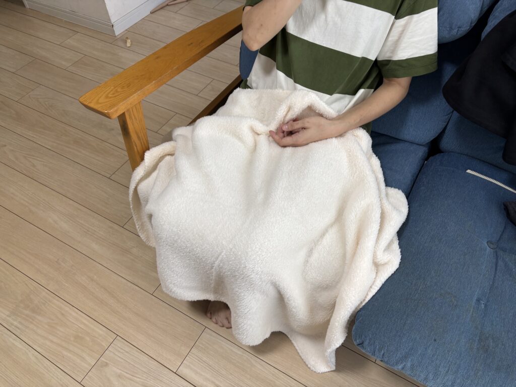 カチオン染めレギュラーブランケット（巾着付）アイボリーを膝に掛けた子供